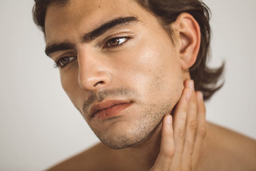 Man touching his jawline