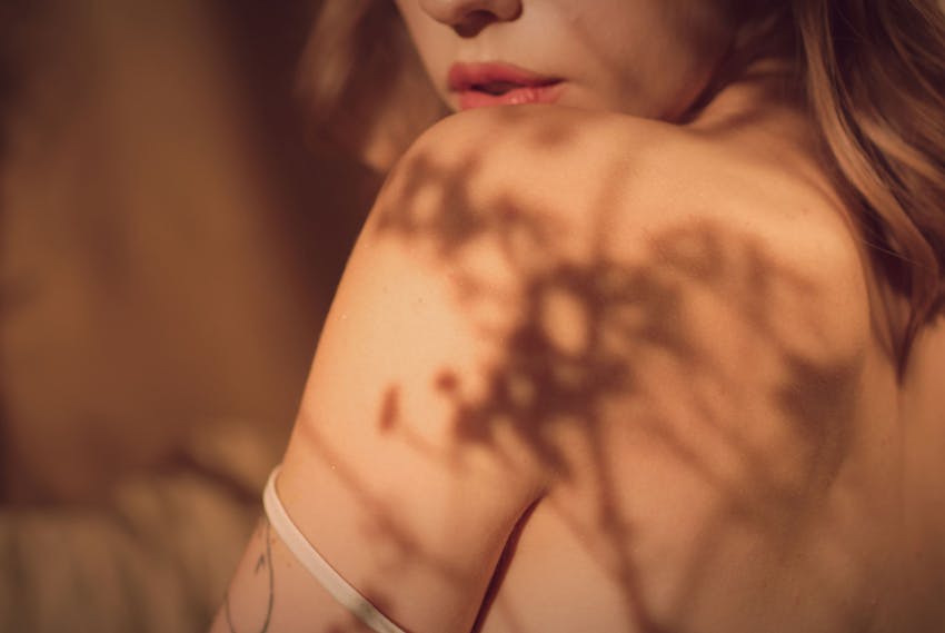 womens shoulder with a shadow of a plant