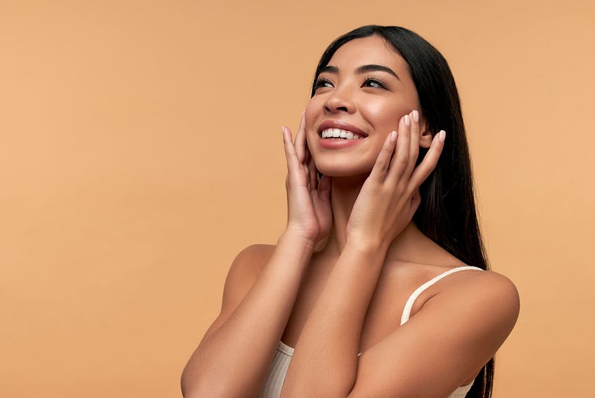 Woman smiling with hands on face