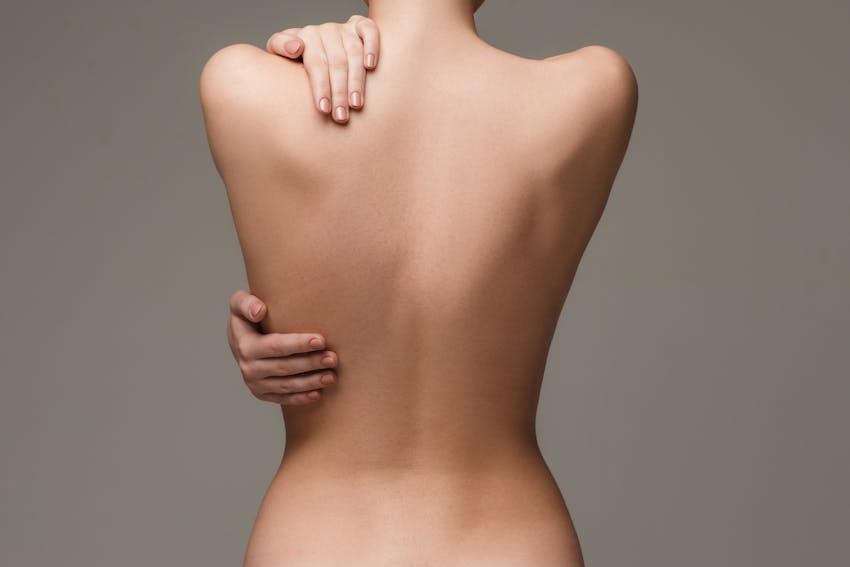 Woman touching her back