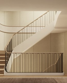 Curving staircase with a bronze balustrade and wall lights, framed by open glass doors in luxury residences in London.