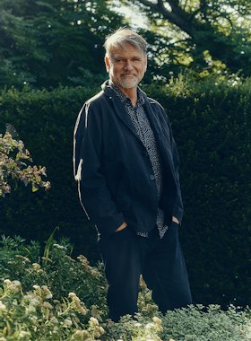 Garden designer Andy Sturgeon standing in front of a clipped hedge
