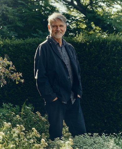 Garden designer Andy Sturgeon standing in front of a clipped hedge