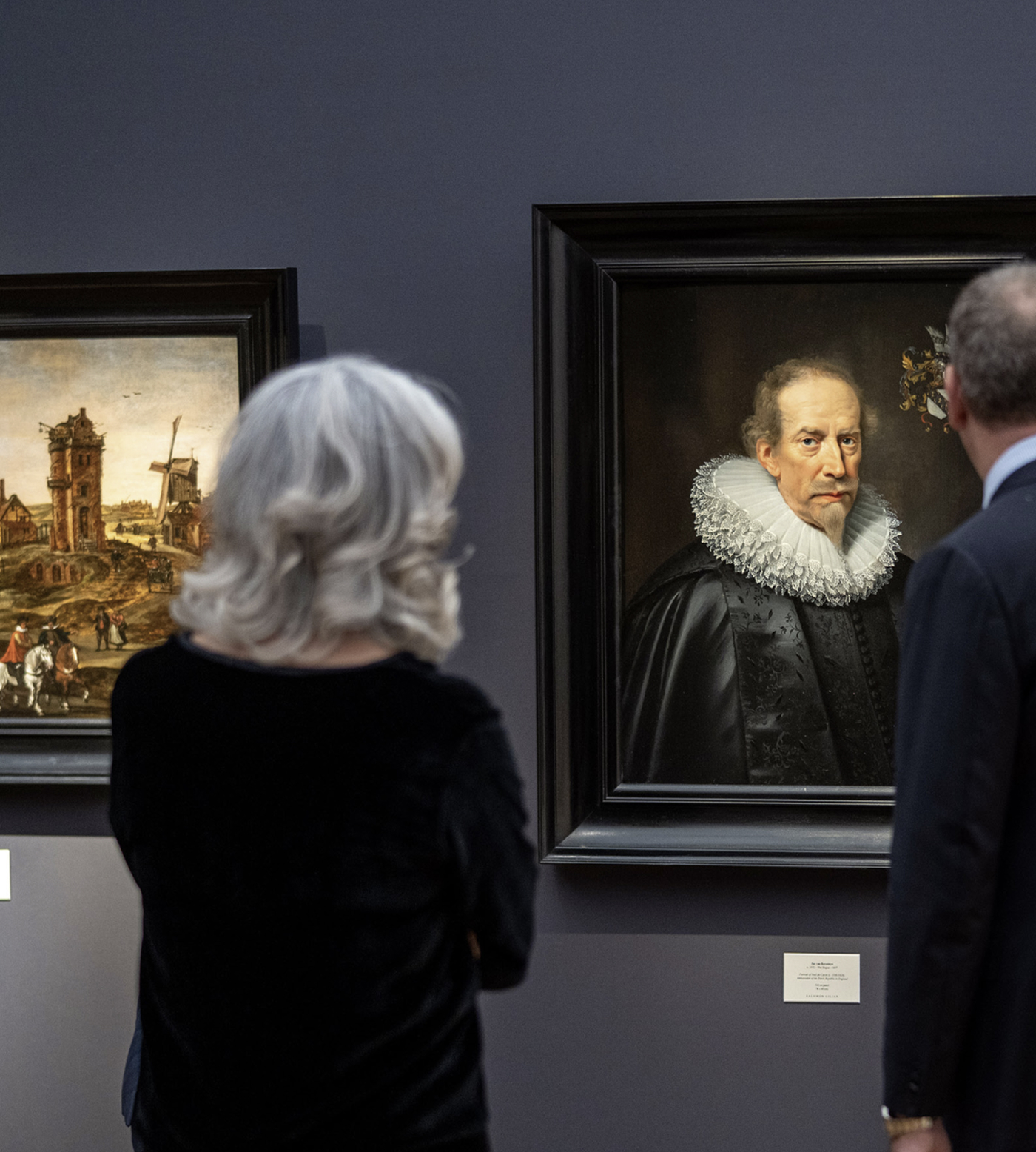Visitors viewing Old Master paintings, including a ruffed-collar portrait, at Frieze