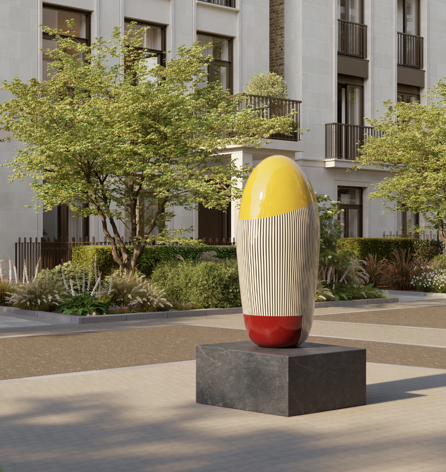Yellow, striped and red egg-shaped sculpture on a stone plinth in front of the residences