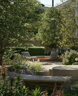 Walled garden with striped lounge chairs and white hydrangeas at a St Johns Wood new build residential development.
