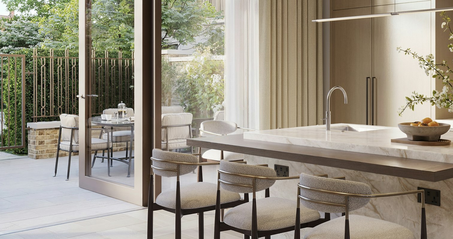 Kitchen island seating four beside timber cabinetry, glazed doors open onto a garden terrace, in a premium apartment in London