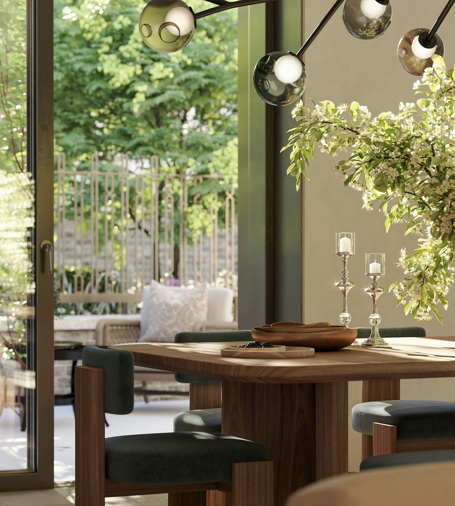 Dining table set with candlesticks before glazed doors looking out onto a planted garden, in luxury apartments in London for sale.