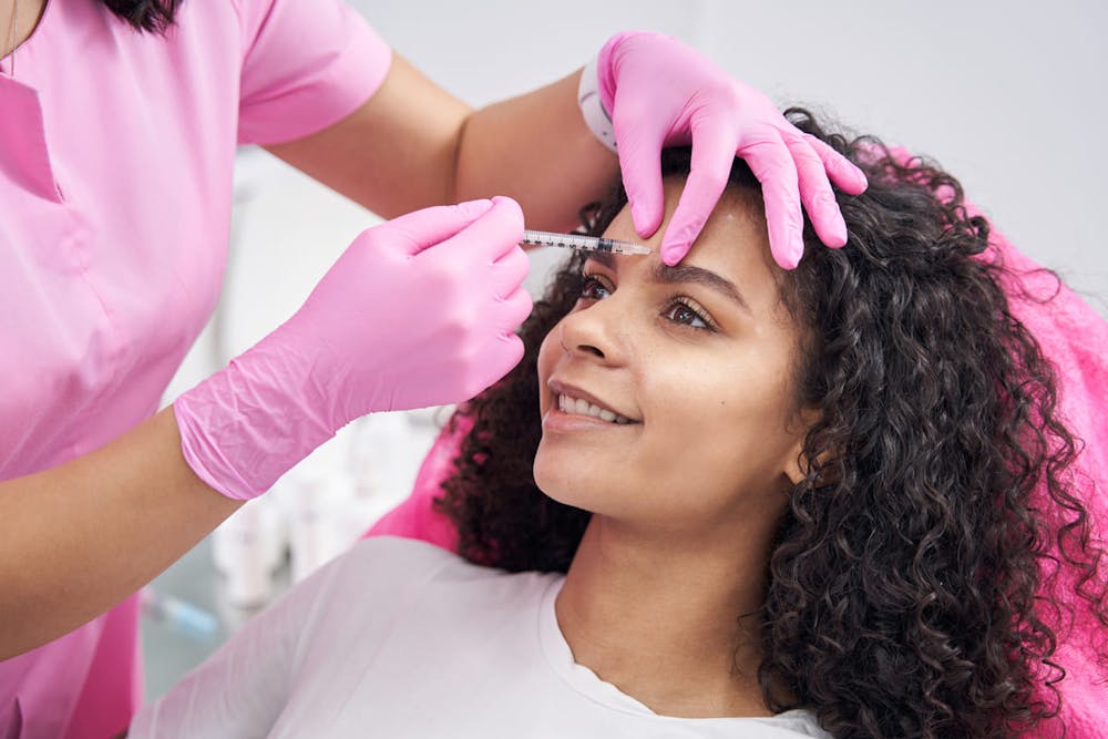 girl hetting forehead botox