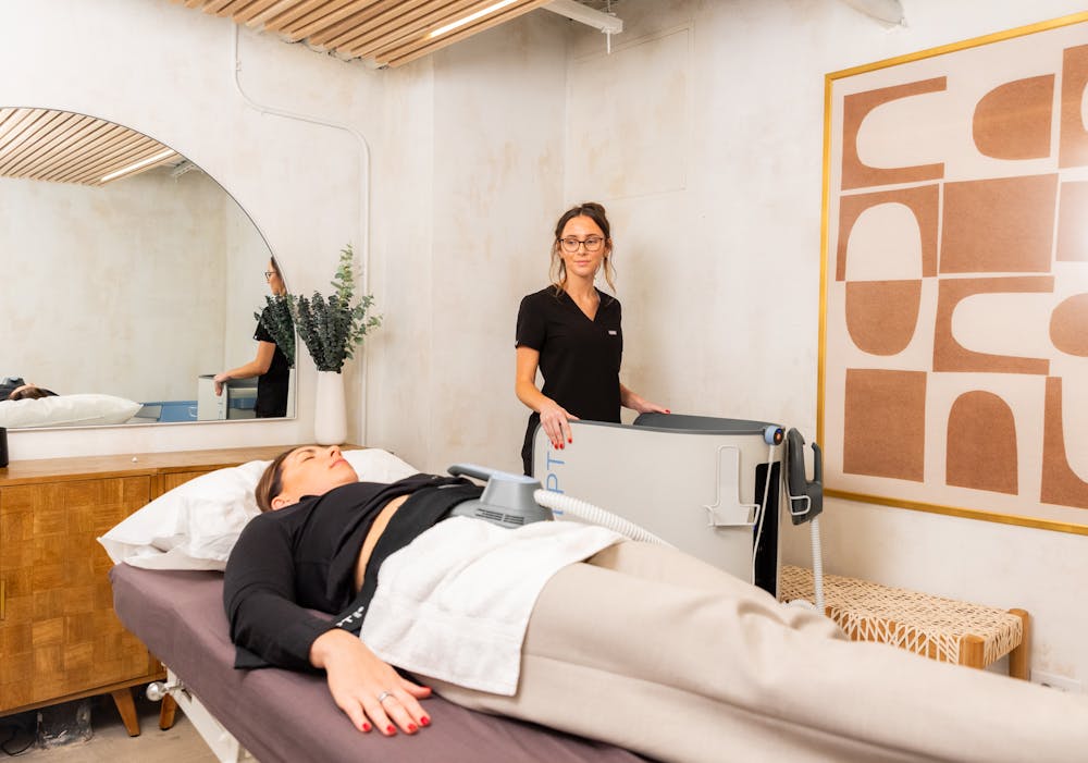 A patient lies down for an Emsculpt NEO treatment as a form of muscle recovery near Lincoln Park Chicago.