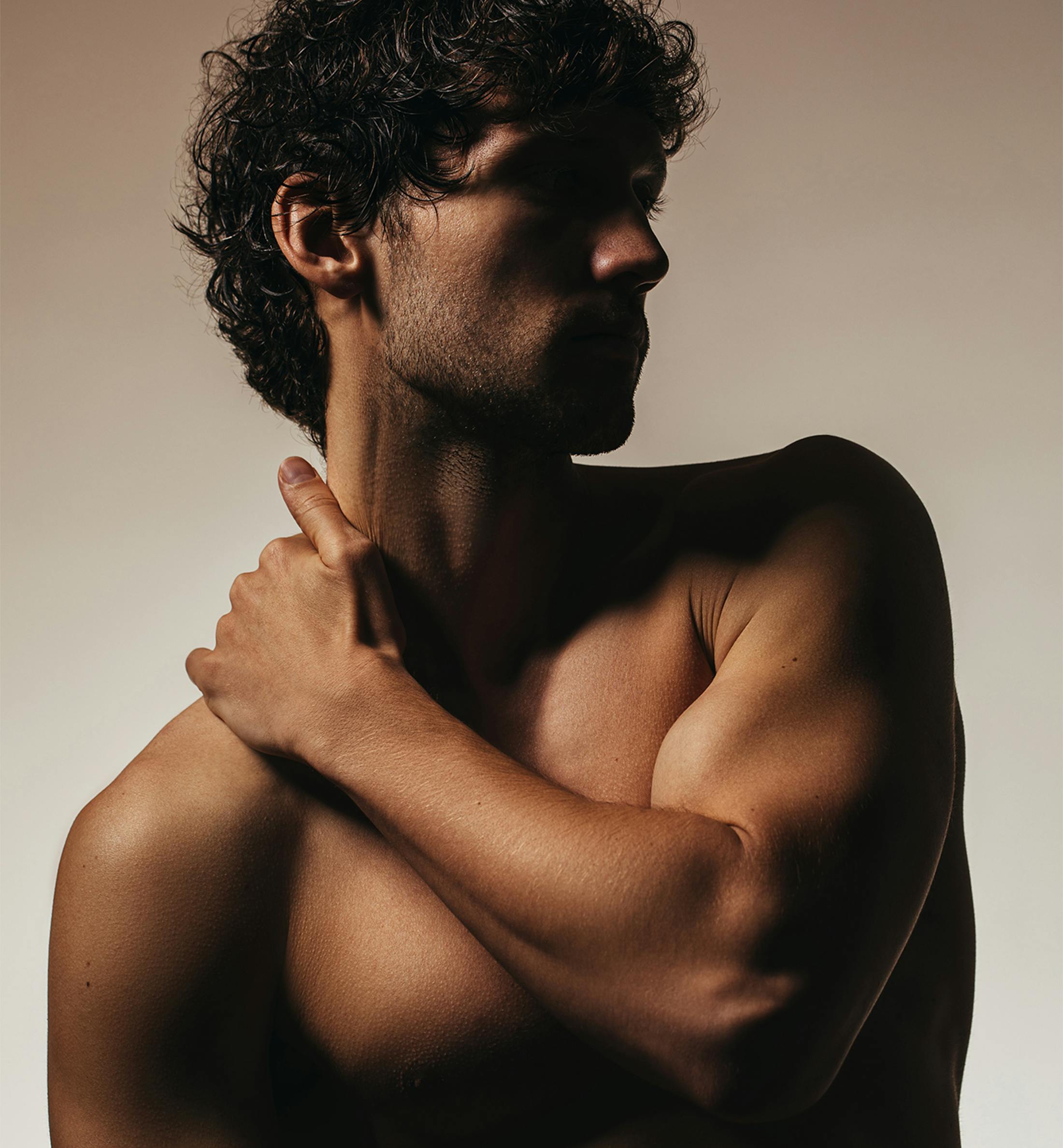 shirtless man in the shadows