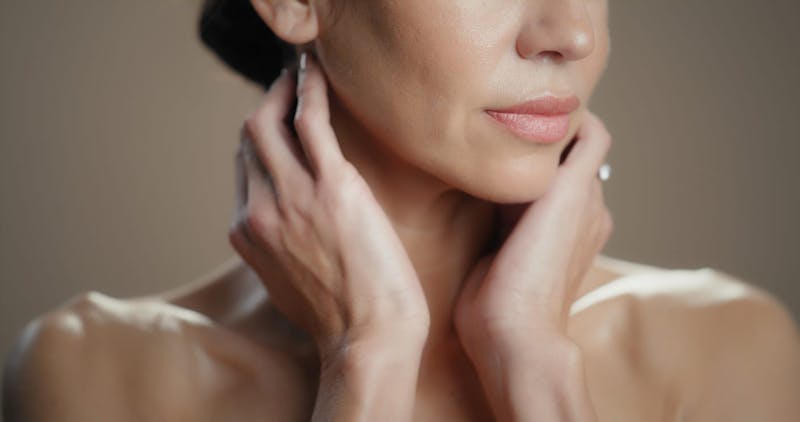 woman touching her neck