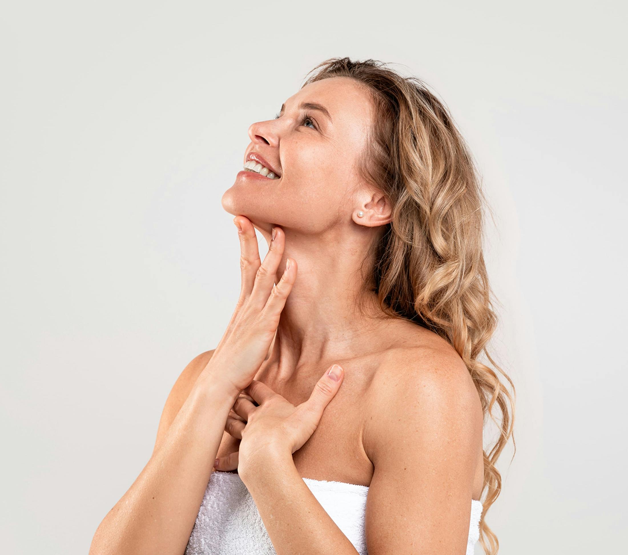 woman smiling touching neck