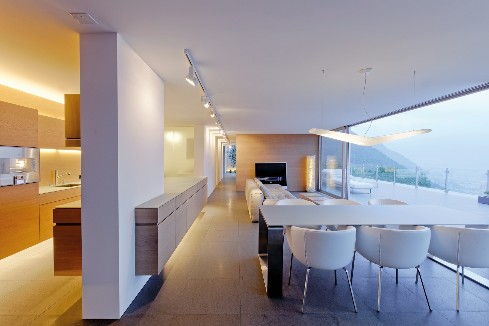 Open living area with kitchen, dining table and fireplace, with terrace views in the terrace apartment in Contra