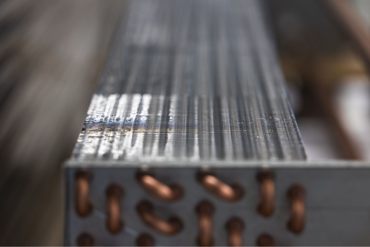 Nahaufnahme eines Wärmetauschers mit Aluminiumlamellen und Kupferrohren einer Riotherm CONVEC-Einheit