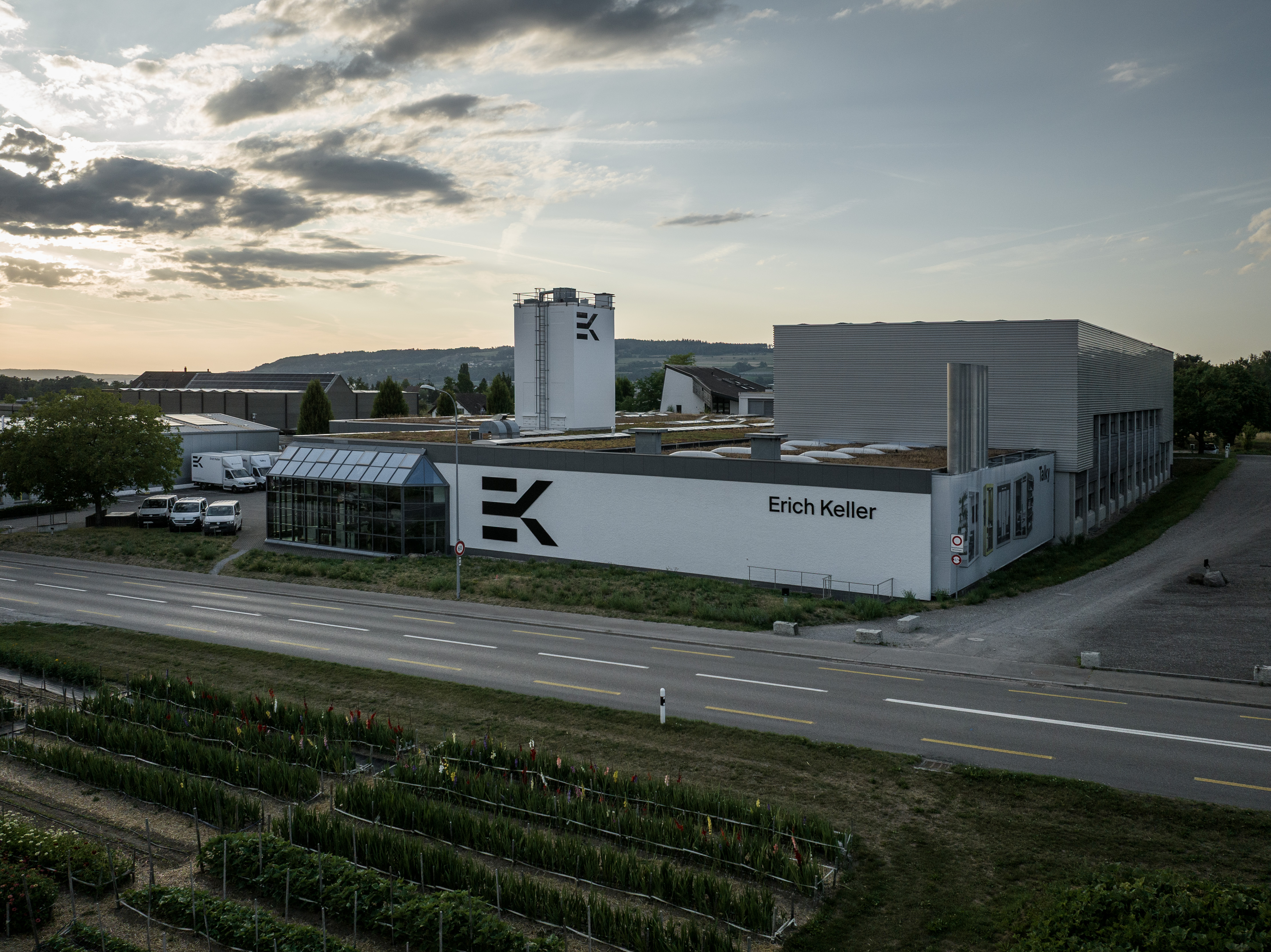 Aerial view of the Erich Keller headquarters building with its logo on the façade and an adjacent plant nursery