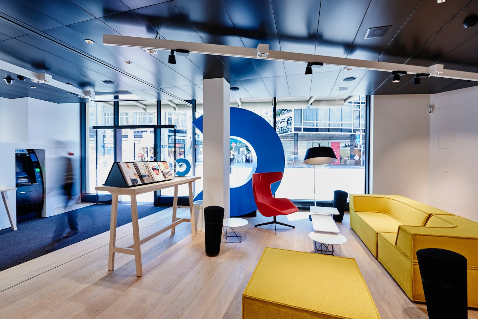 Bank branch with a colourful lounge area, a red armchair and a yellow seating group