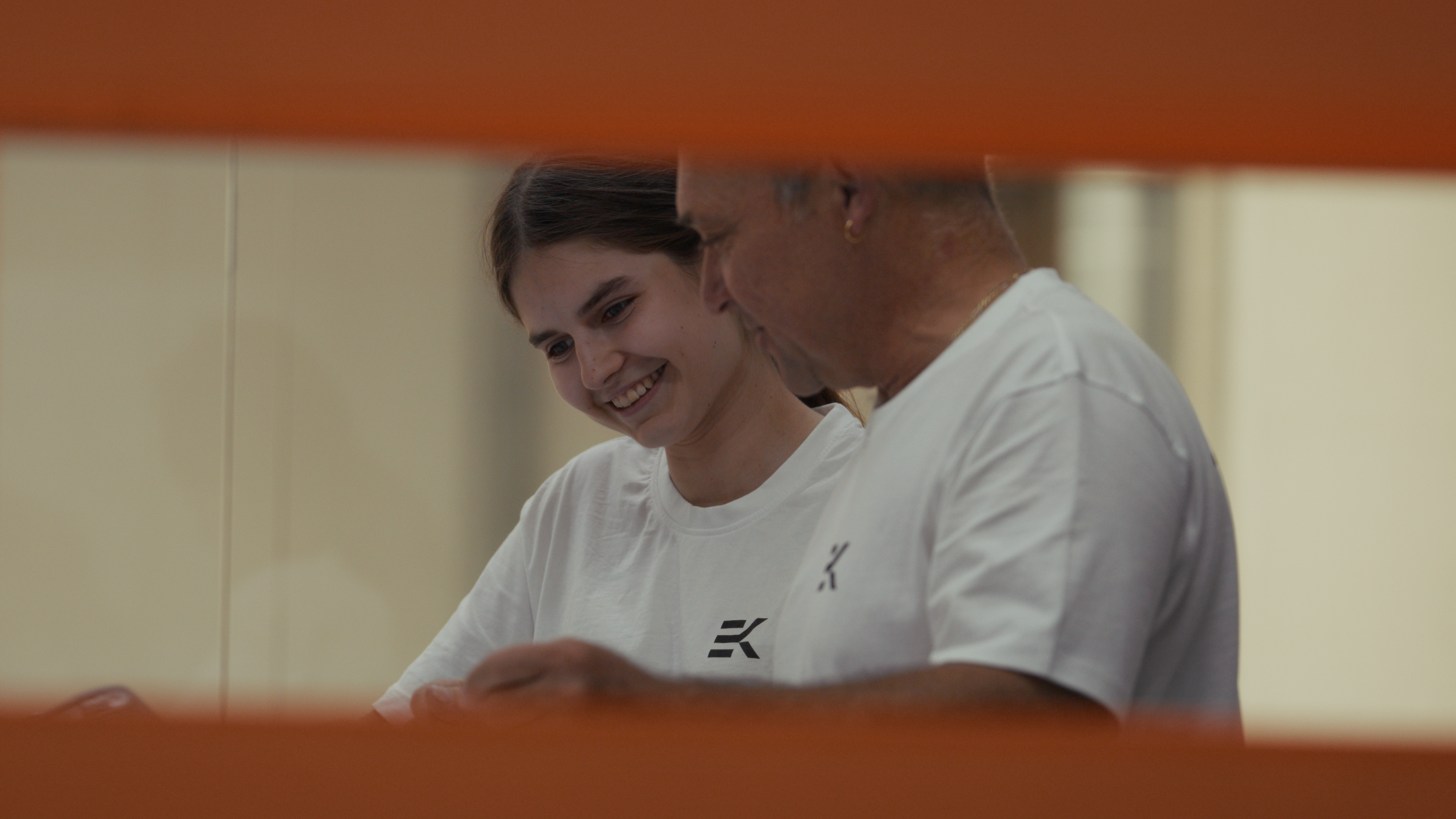 Junge Mitarbeiterin und Kollege lächeln gemeinsam während der Arbeit in der Werkstatt