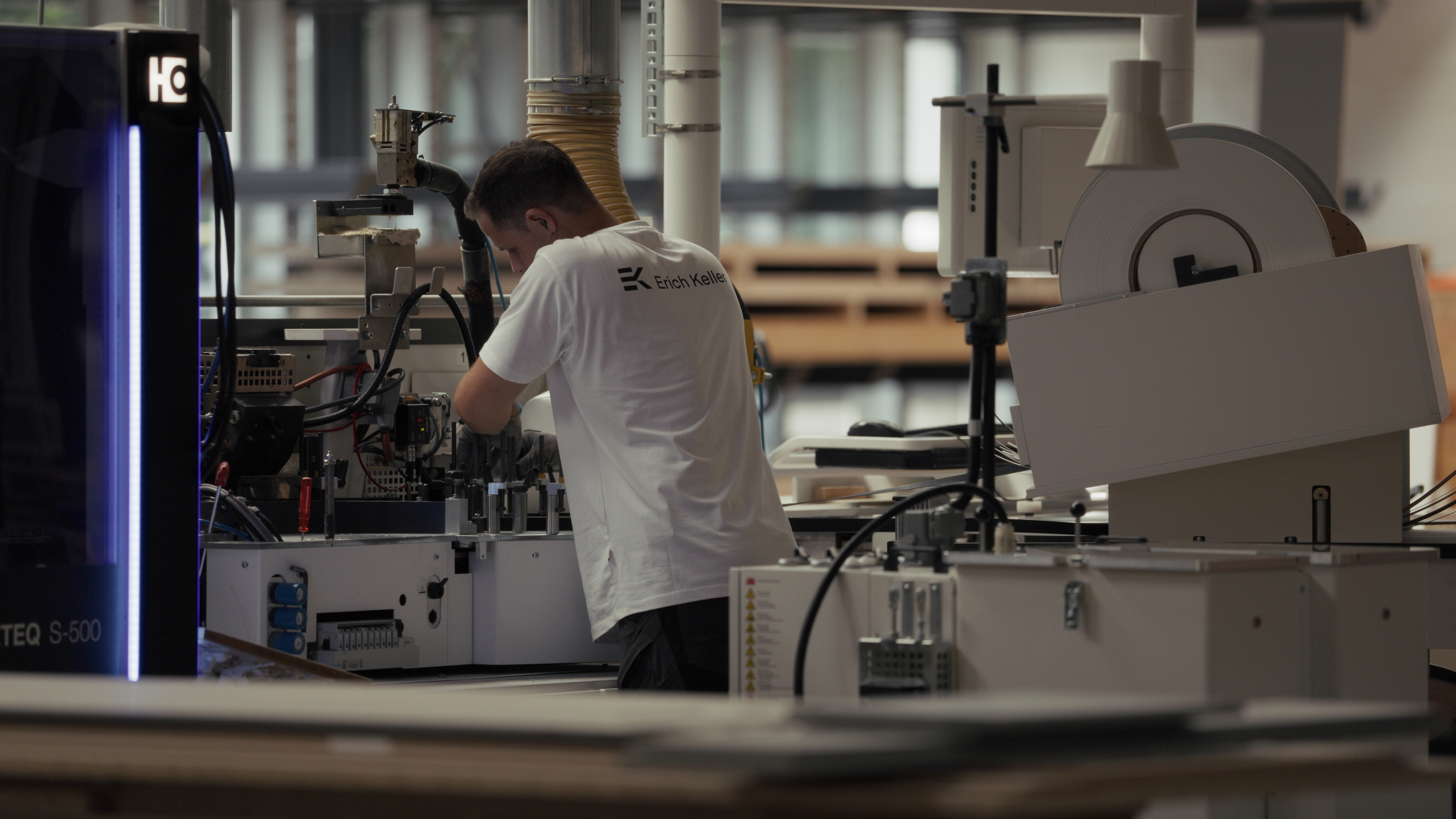 Mitarbeiter bedient eine CNC-Maschine in der Erich Keller Produktionshalle
