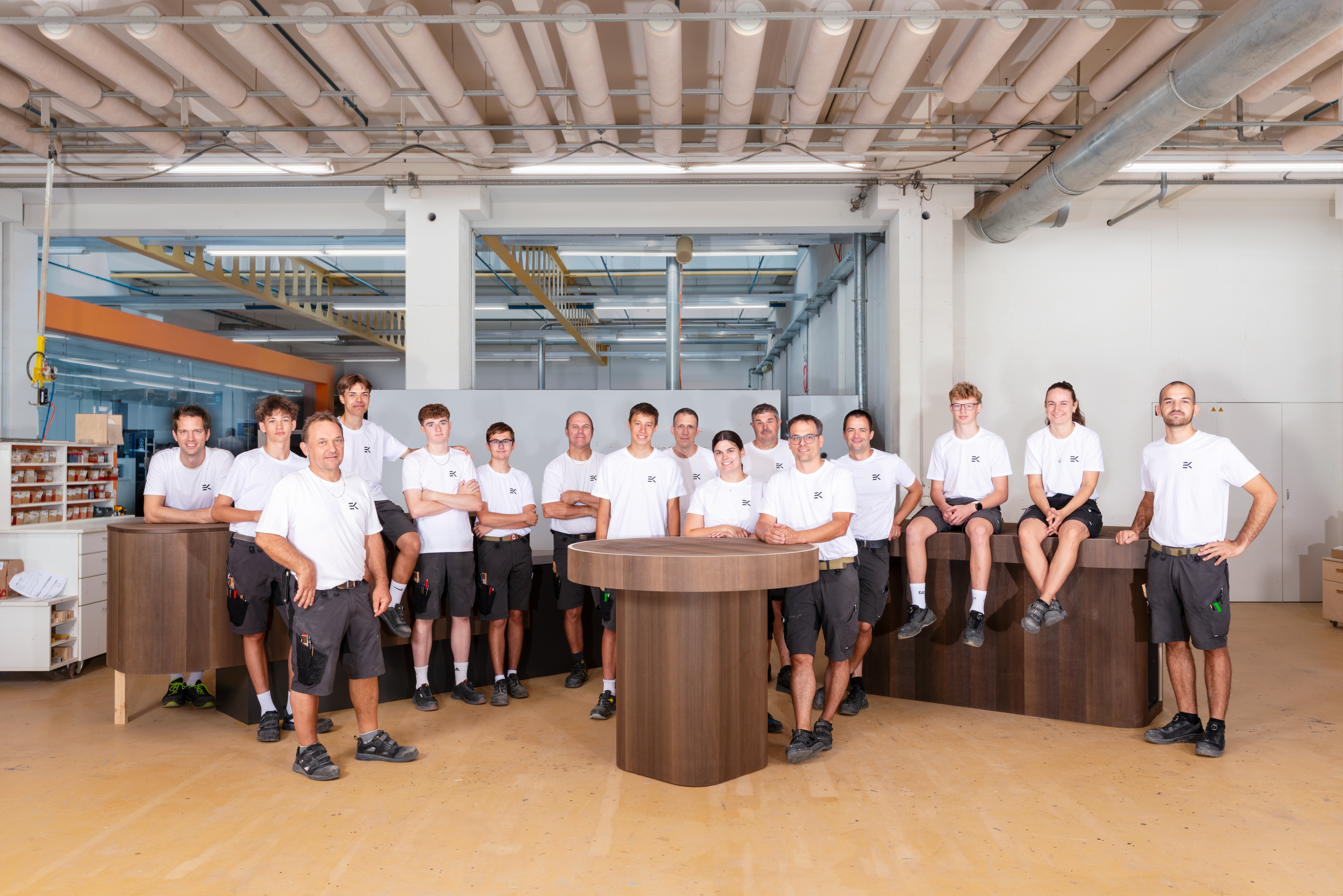 Grosses Team von Erich Keller um einen massgefertigten Holztisch in der Schreinerei