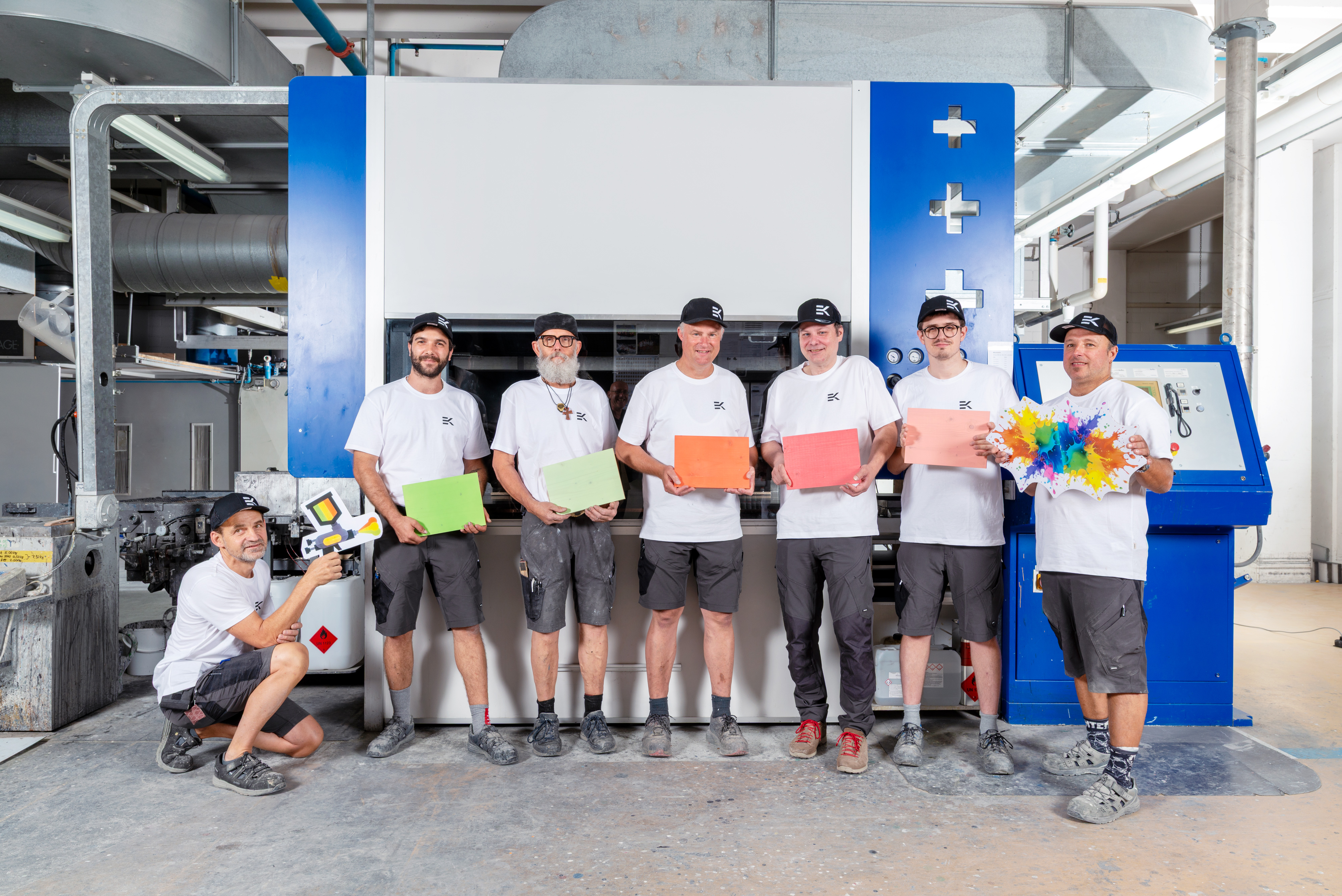 Team der Oberflaechenbearbeitung der Erich Keller AG vor einer Lackieranlage in der Werkstatt