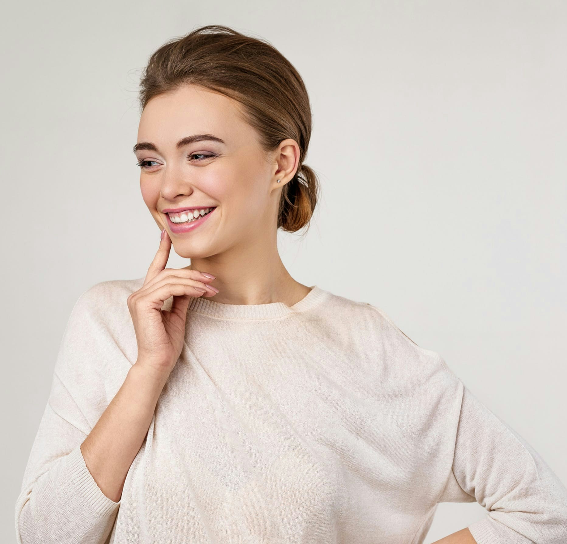 Woman smiling and touching her face