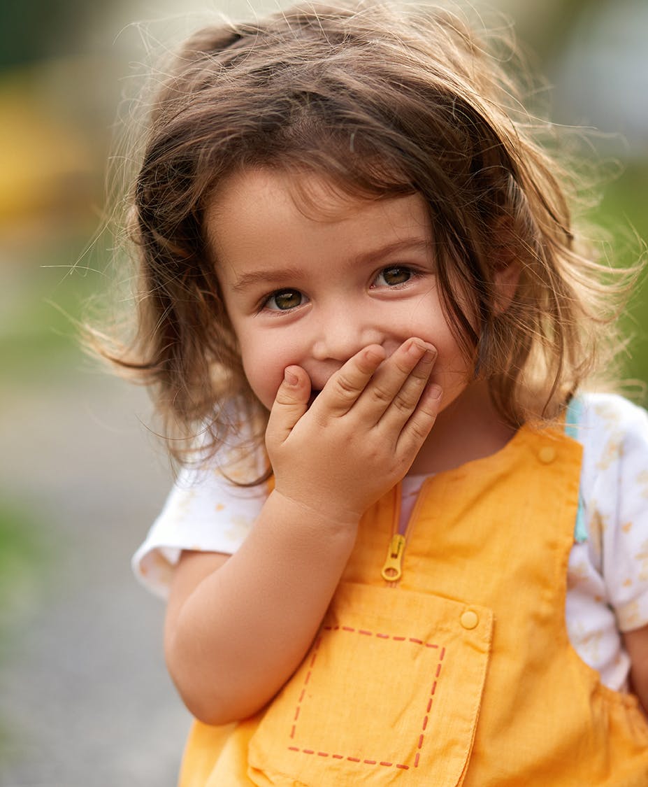 female child with hand on mouth