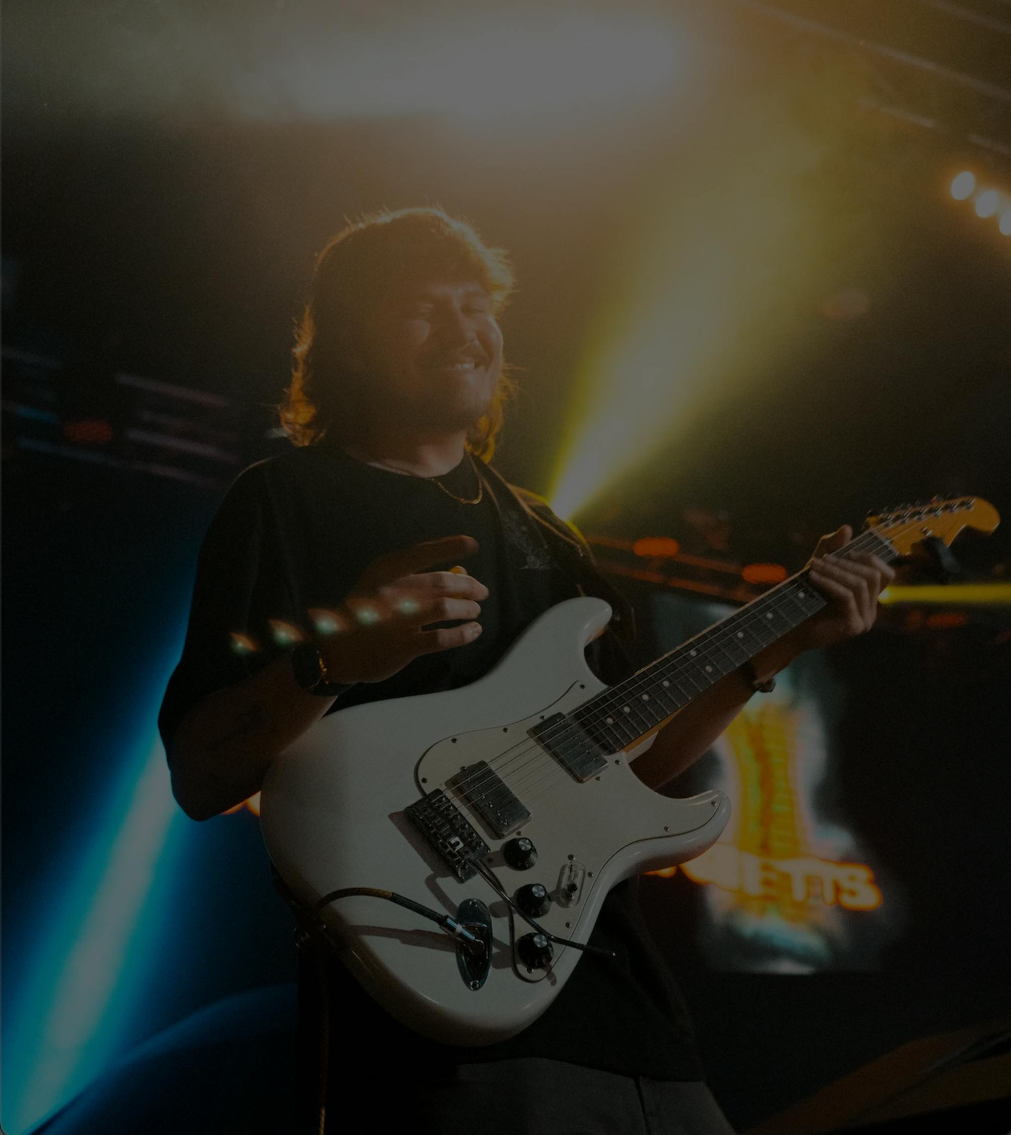 Jeremy Schmetterer on stage playing an electric guitar