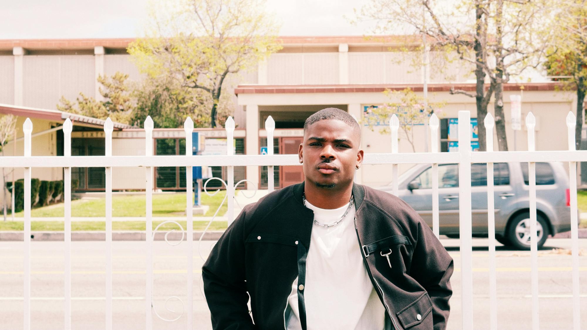 Gemaine Edwards sitting on a ledge outside in a suburban area.
