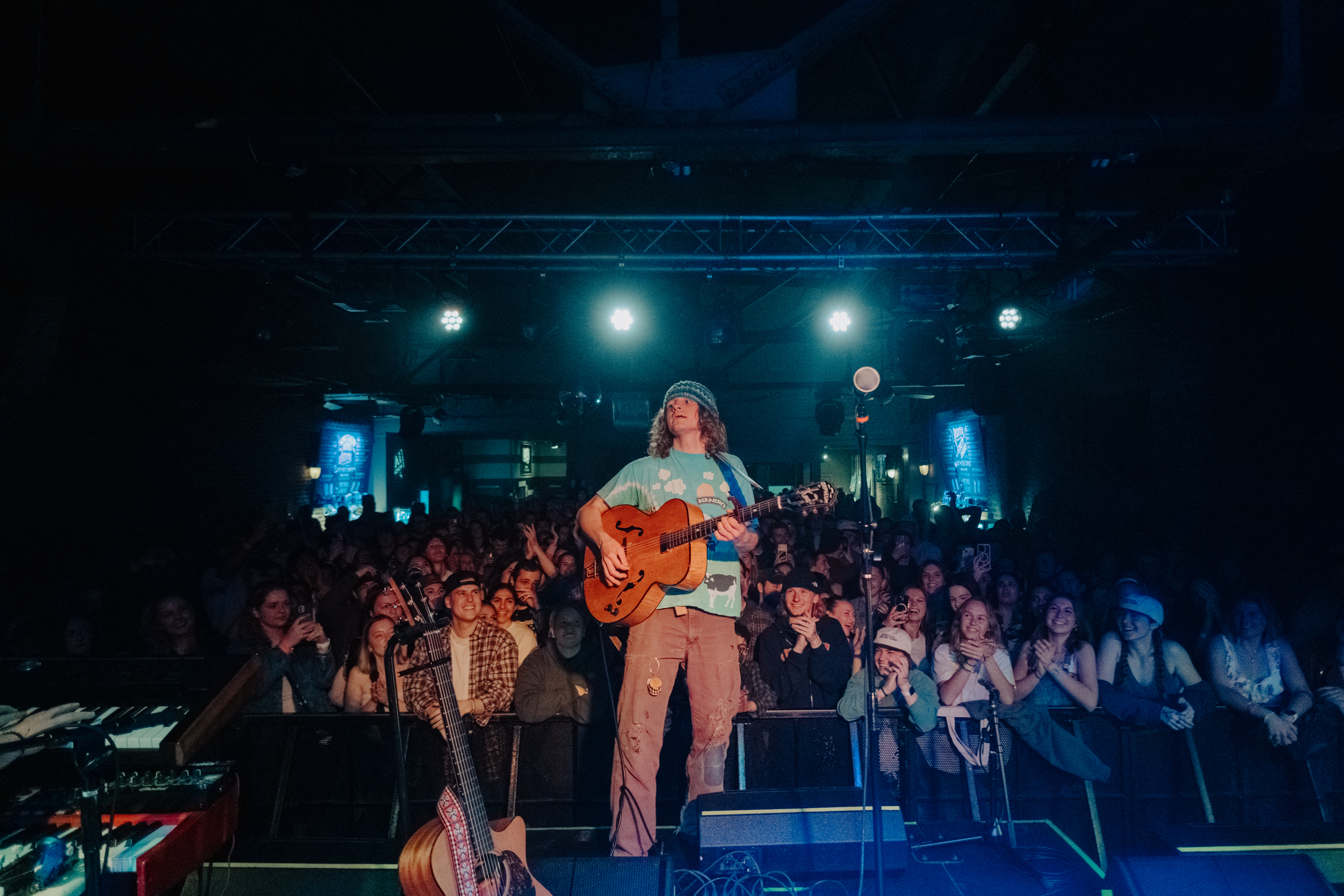 Hans Williams performing live in front of a crowd at a small indoor music venue