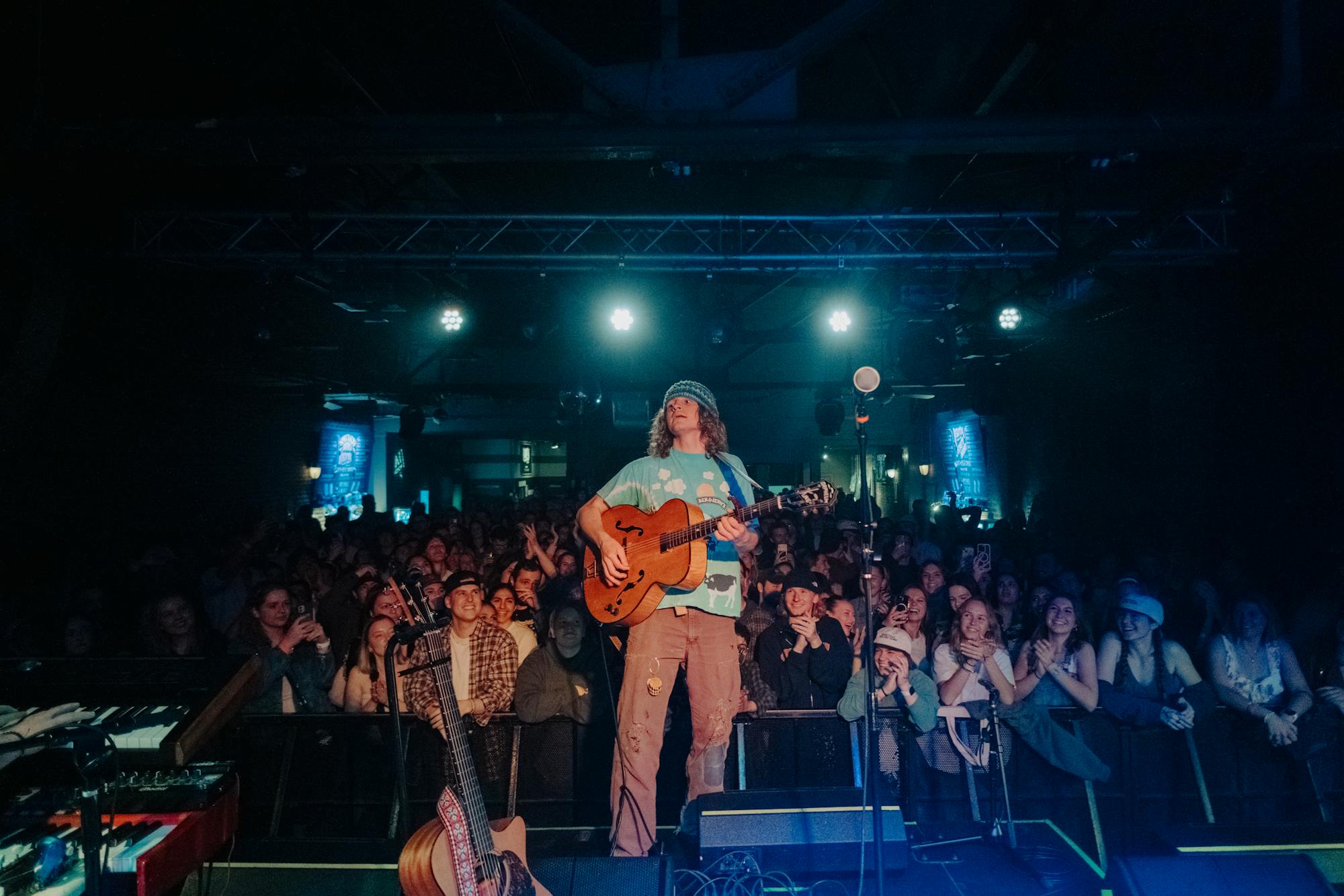 Hans Williams performing live in front of a crowd at a small indoor music venue