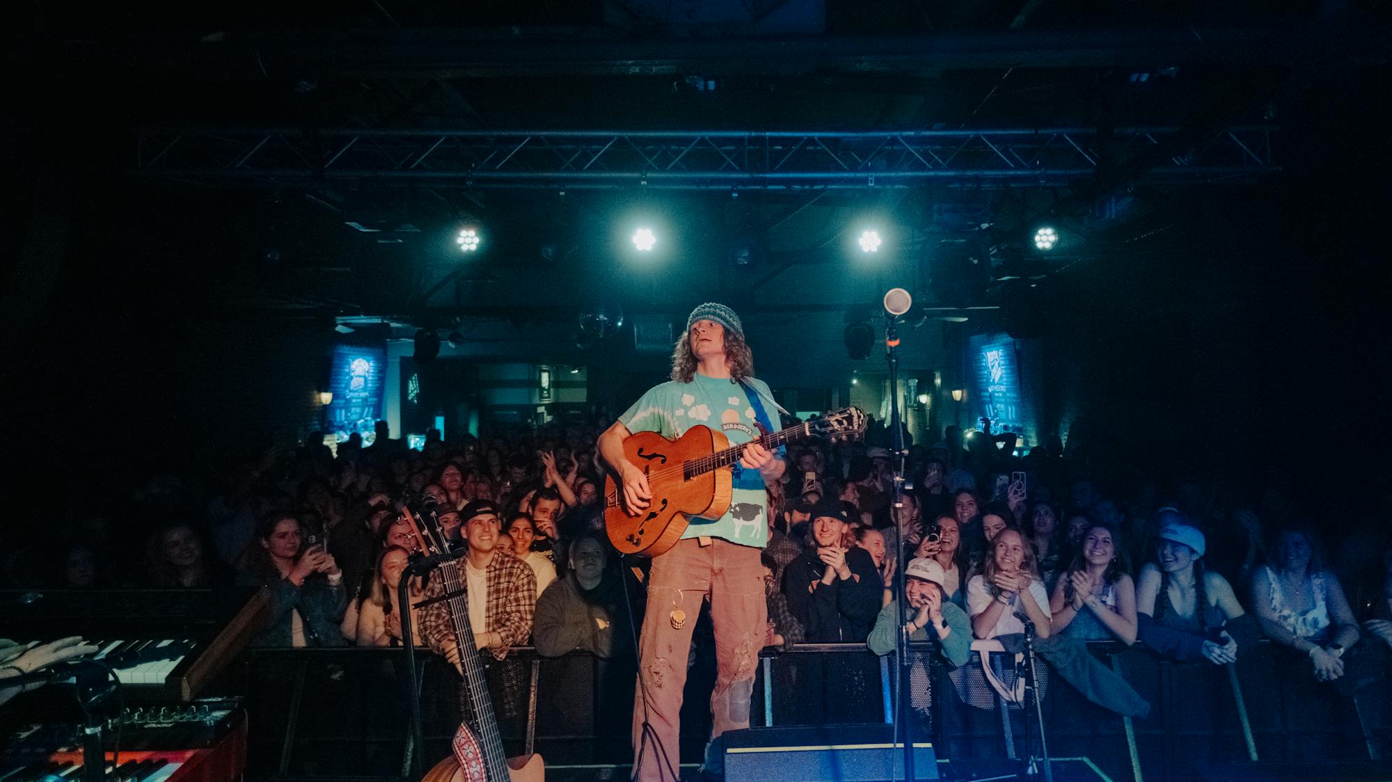 Hans Williams performing live in front of a crowd at a small indoor music venue