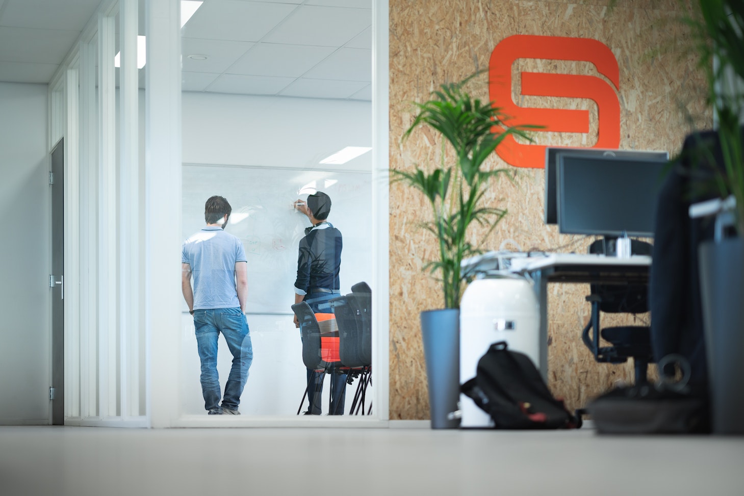 Guys discussing in front of whiteboard