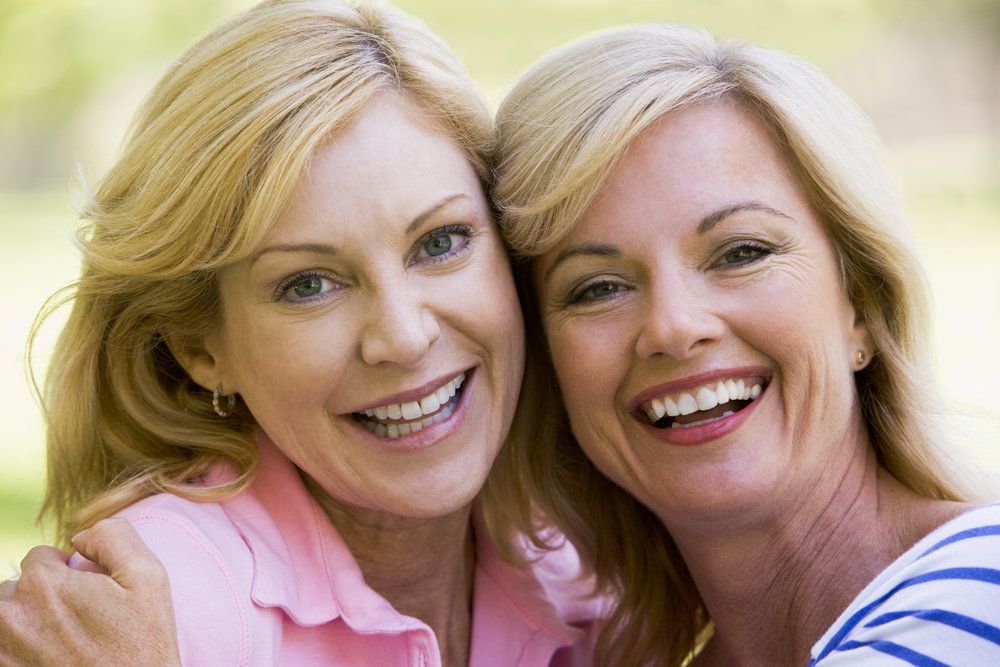 Two women with healthy, clean smiles