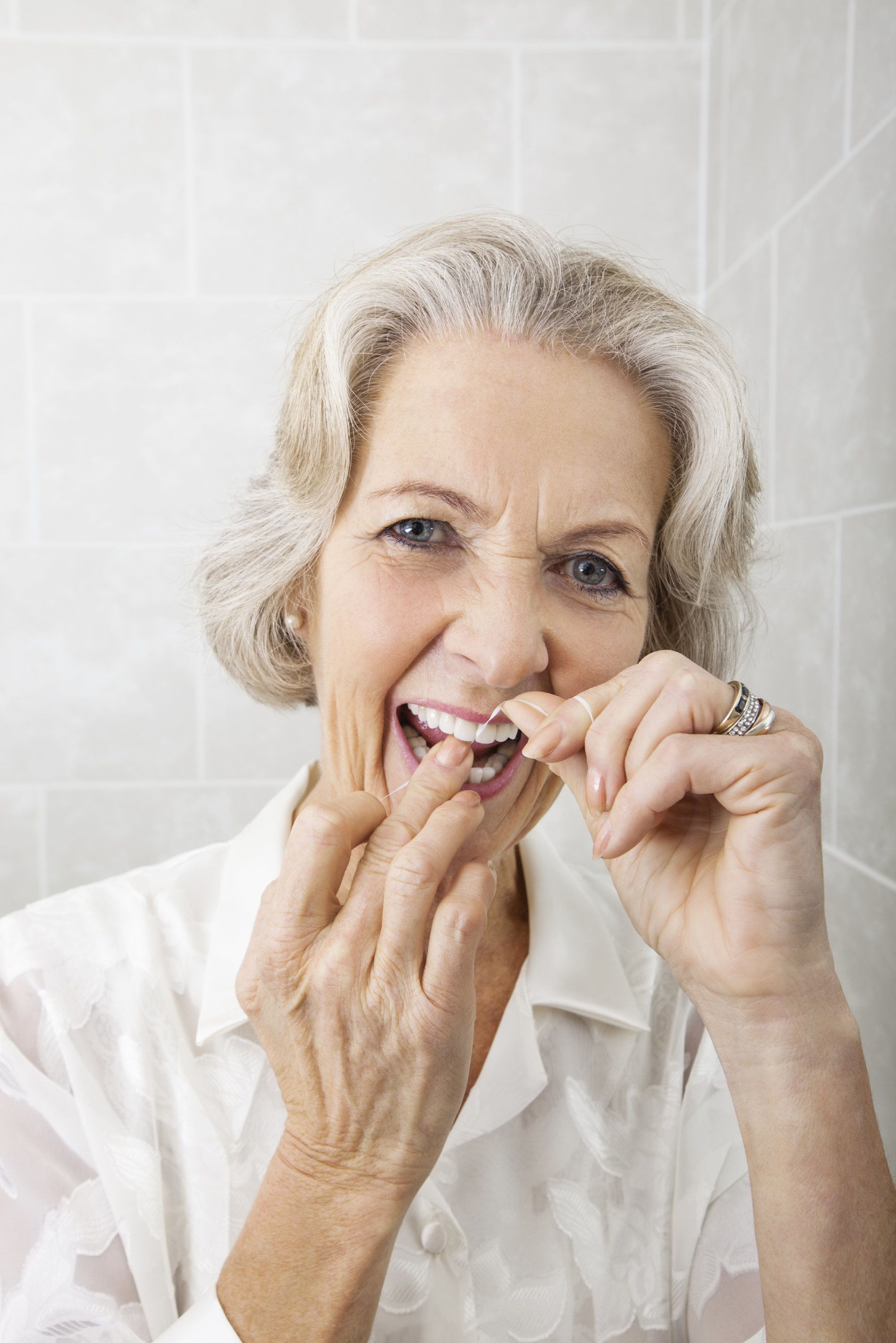 A woman flossing her teeth