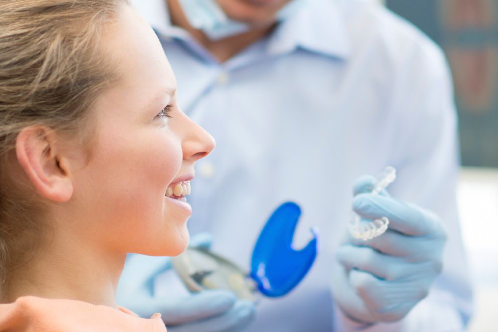 Young female patient receiving Invisalign® tray