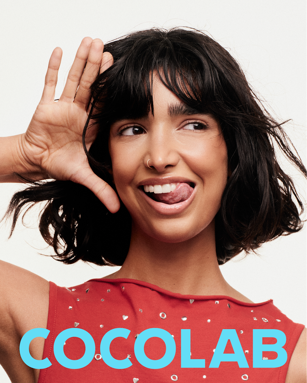 Portrait from the Cocolab campaign featuring a woman posing playfully against a white background.