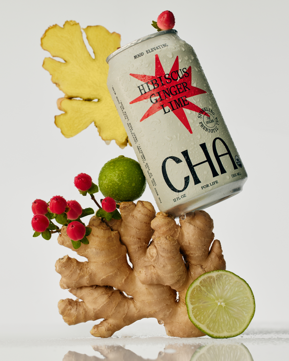 A photography of a can of Cha in balance with Ginger, Lime & Hibiscus. On a white background.