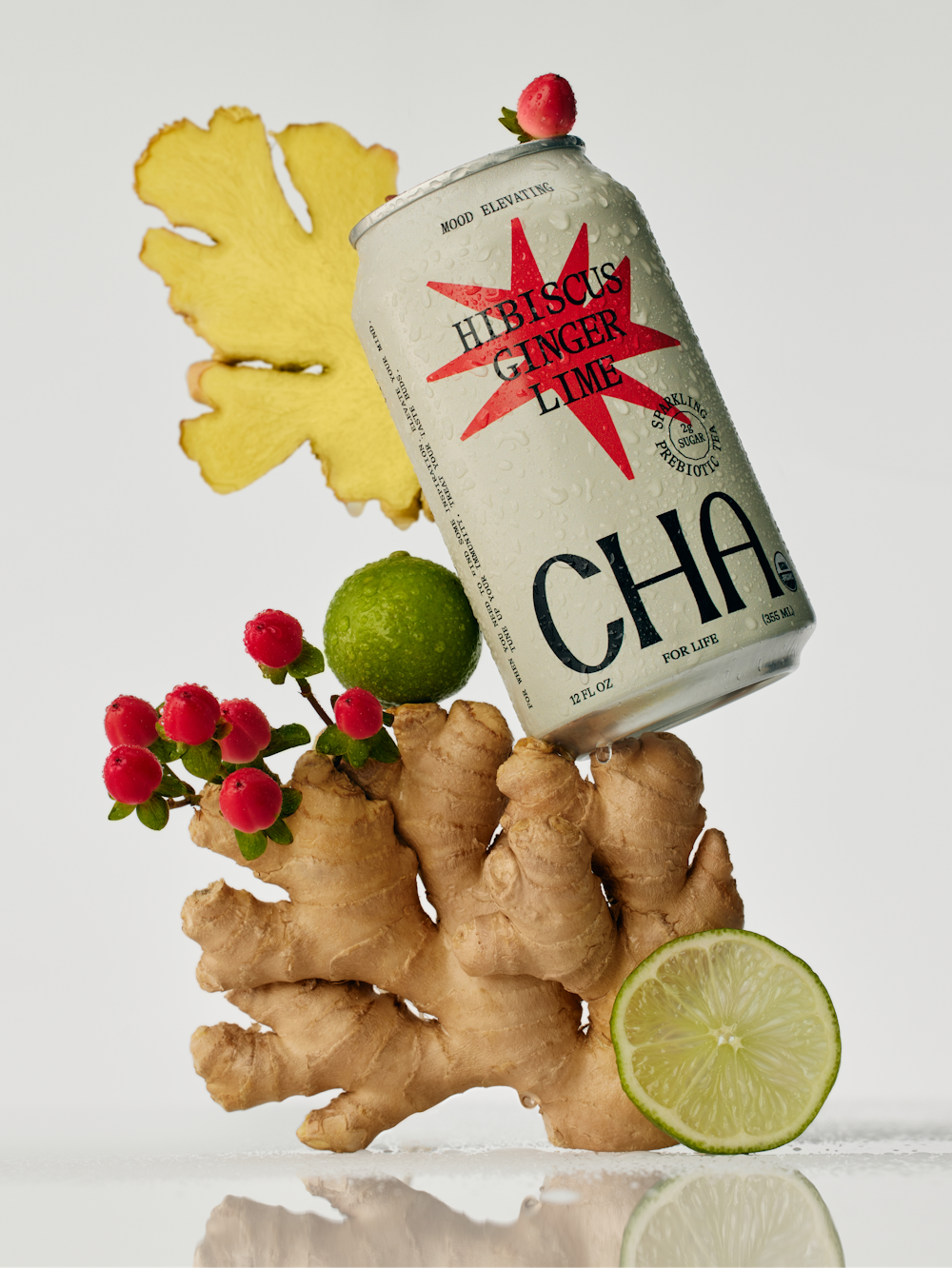 A photography of a can of Cha in balance with Ginger, Lime & Hibiscus. On a white background.