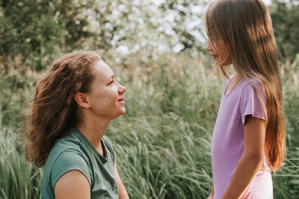 Mother and daughter in conversation outdoors, considering ear maturation for surgery.