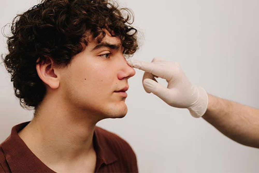 man getting nose surgery inspection