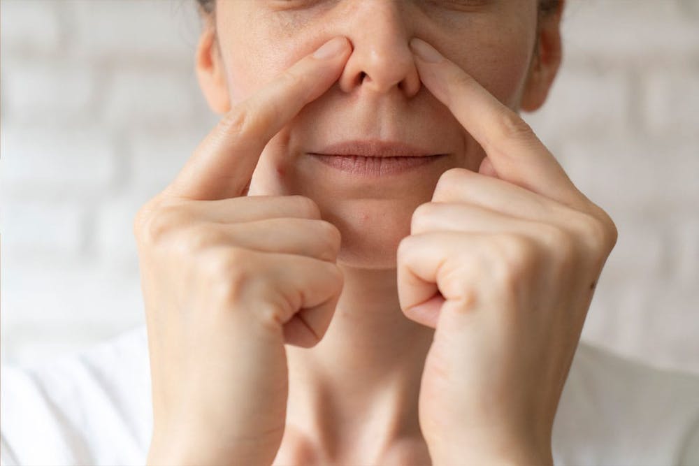 what-can-a-functional-rhinoplasty-help-fix-1 woman feeling her nasal obstruction before getting a functional rhinoplasty in Miami, FL