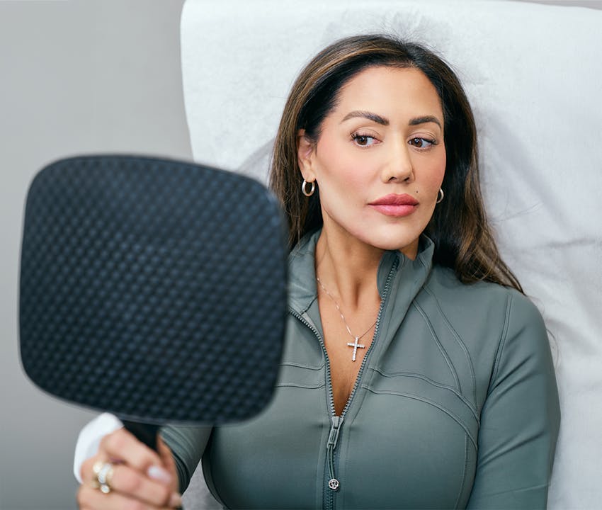 women holding a mirror up to her face