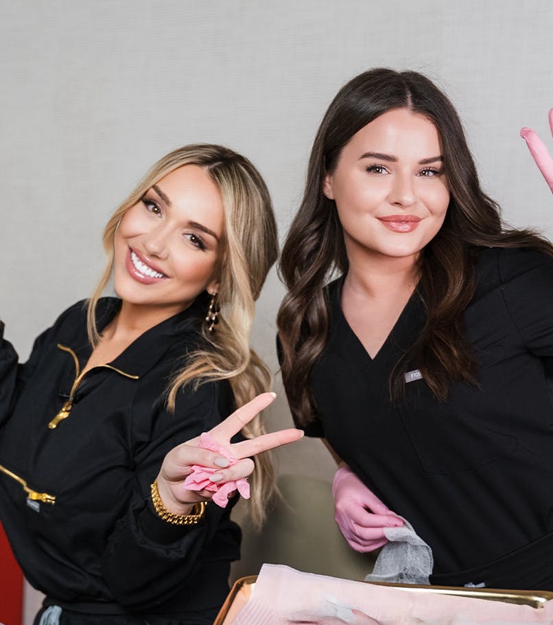 two team members throwing up peace signs