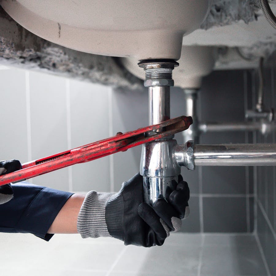 plumber working under sink