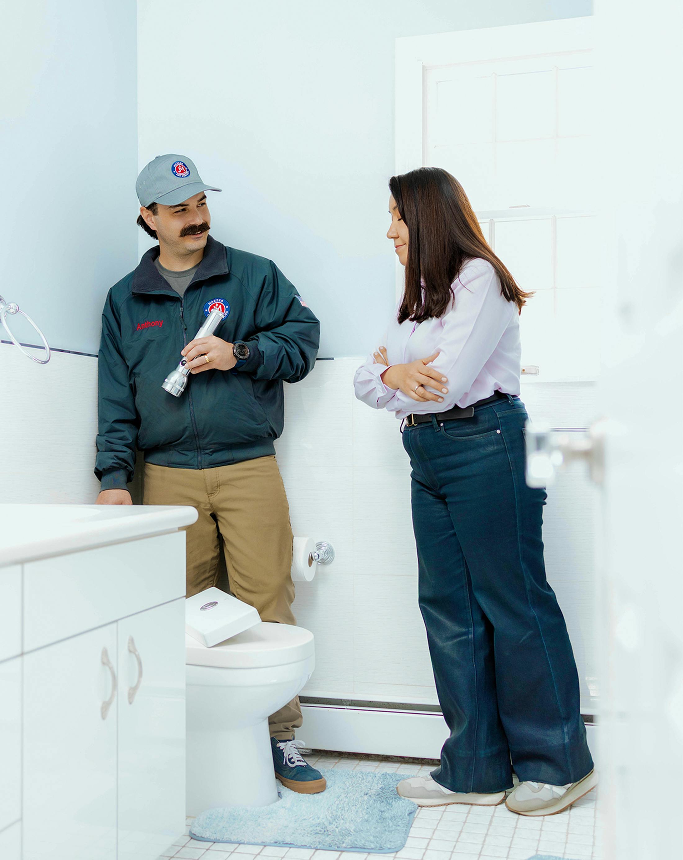 plumber with client in bathroom