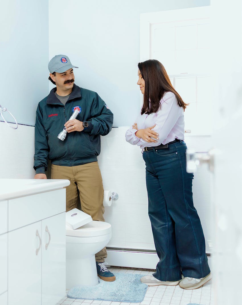 plumber with client in bathroom