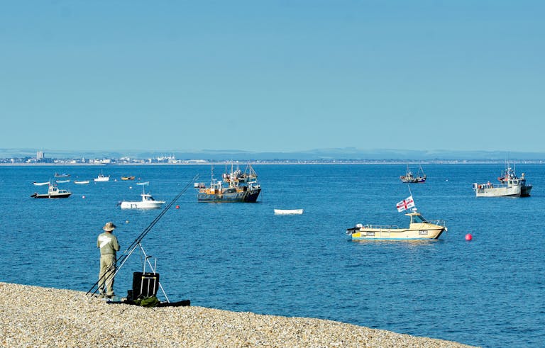Sea angler at East Beach with the fishing boats in the background