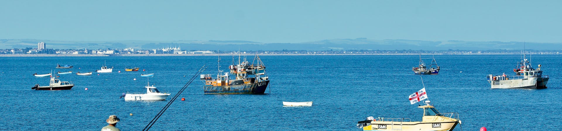 Sea angler at East Beach with the fishing boats in the background
