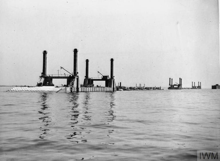 Spud Pierheads at anchor off Selsey Bill, courtesy of IWM Mulberry Harbour: Spud pierheads at anchor off Selsey Bill. They are part of the prefabricated Mulberry ports, various components of these, known as Phoenixes and Whales, were assembled here during the three weeks preceding D-Day.